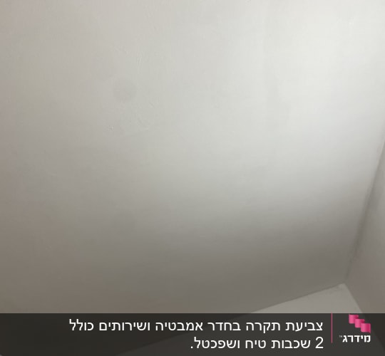 קיר צבוע בלבן עם סימני צבע שונים